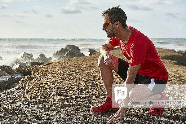 Mann mit Sonnenbrille am Strand an einem sonnigen Tag