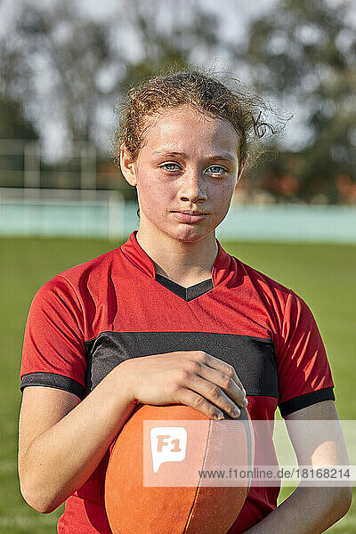 Girl with rugby ball on sunny day