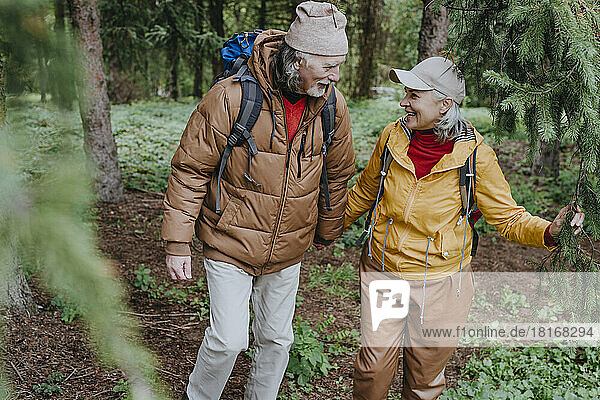 Mature woman and man walking together in forest