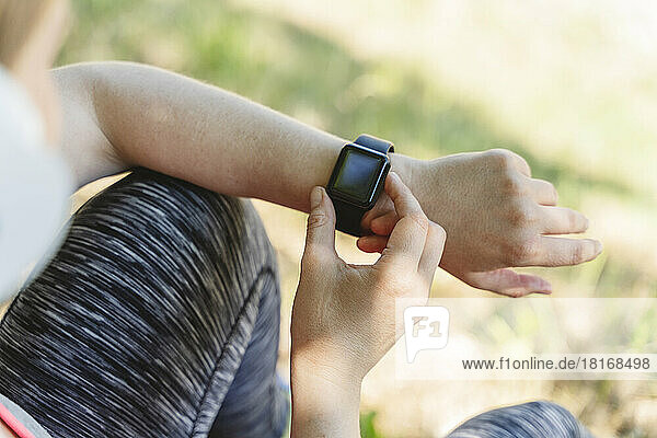 Woman checking pulse on smart watch