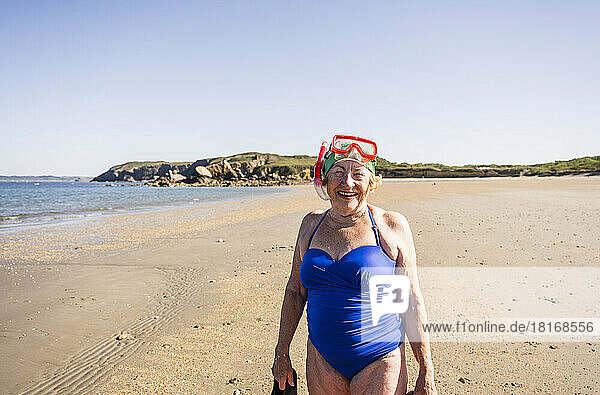 Woman wearing diving goggles and snorkel mask at beach
