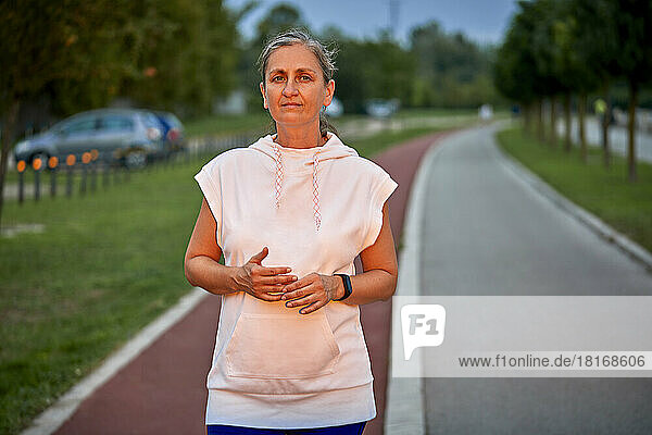 Confident woman standing on sports track