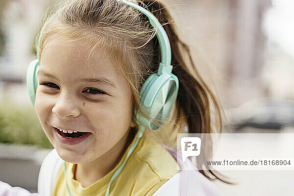 Fröhliches Mädchen  das über Kopfhörer Musik hört