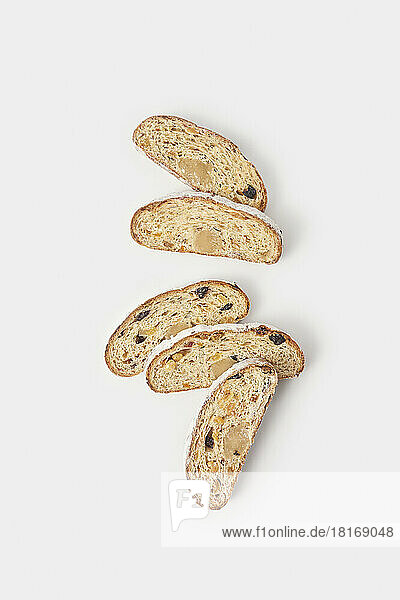 Pieces of Christmas stollen cakes with dried fruits arranged on white background