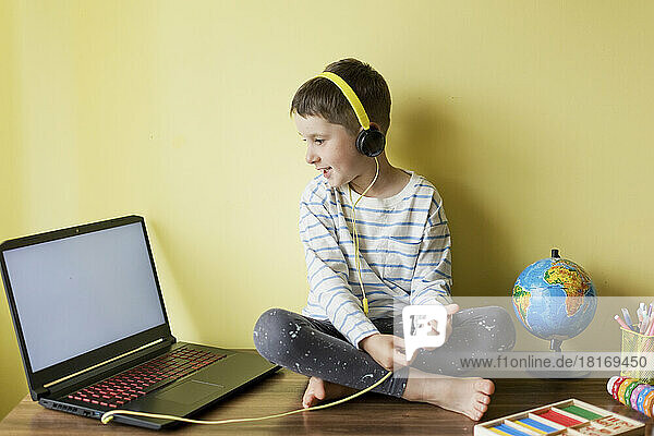 Smiling boy wearing headphones during homeschooling