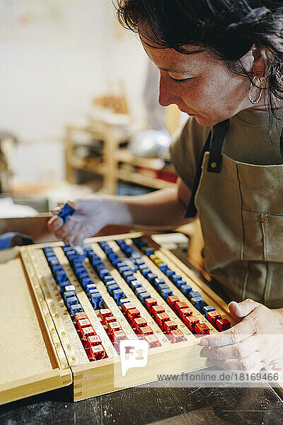 Entrepreneur with box of stamps working at ceramics workshop
