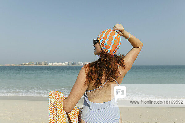Woman wearing swimsuit enjoying sunny day at beach