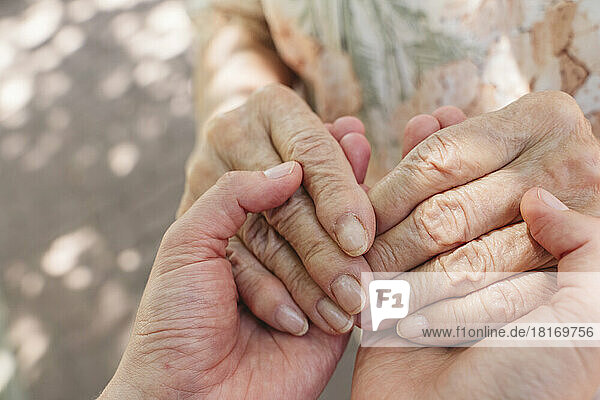 Senior woman holding hands of granddaughter