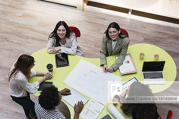 Portrait of confident business team having a meeting at table in conference room