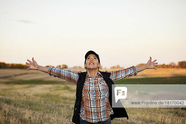 Portrait of a woman feeling a sense of joy after completing a fall Canola harvest; Alcomdale  Alberta  Canada
