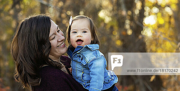 Porträt einer Mutter und ihres kleinen Mädchens mit Down-Syndrom  die während eines Familienausflugs in einem Stadtpark im Herbst viel Zeit im Freien verbringen; St. Albert  Alberta  Kanada