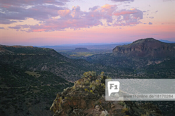 Gorges and rock formations on a vast desert landscape at sunset; New Mexico  United States of America