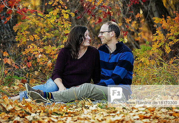 A married couple spending quality time together outdoors in a city park during the fall season; St. Albert  Alberta  Canada