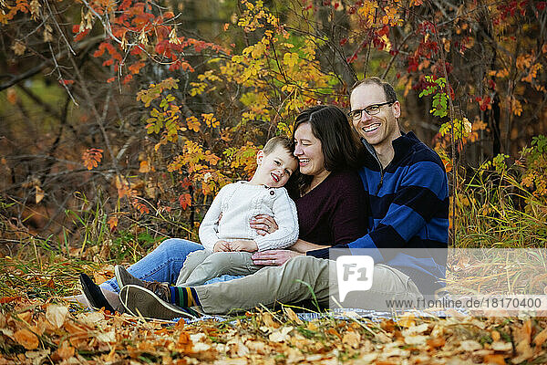 Eine Mutter und ein Vater  die mit ihrem Sohn bei einem Familienausflug in einem Stadtpark während der Herbstsaison einige Zeit verbringen; St. Albert  Alberta  Kanada