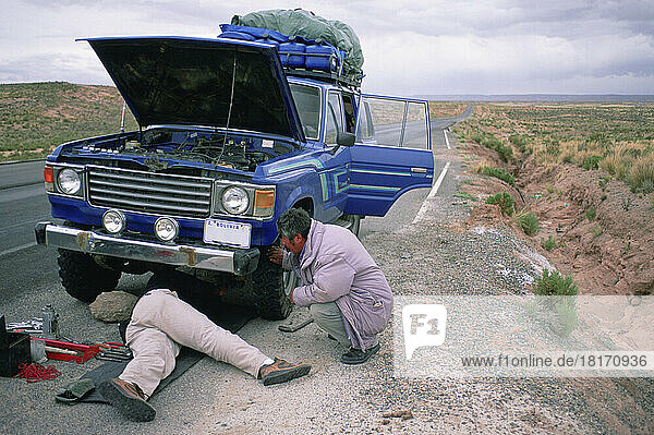 Two men work on a vehicle in the Atacama desert of Chile; Atacama desert  Chile