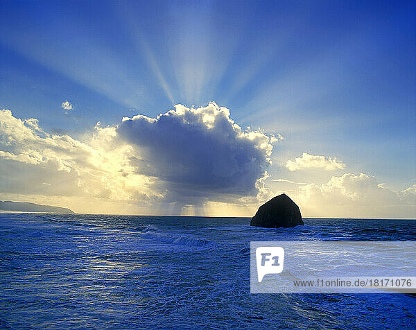 Sonnenstrahlen aus einer Wolkenformation über blauem Ozeanwasser; Oregon  Vereinigte Staaten von Amerika
