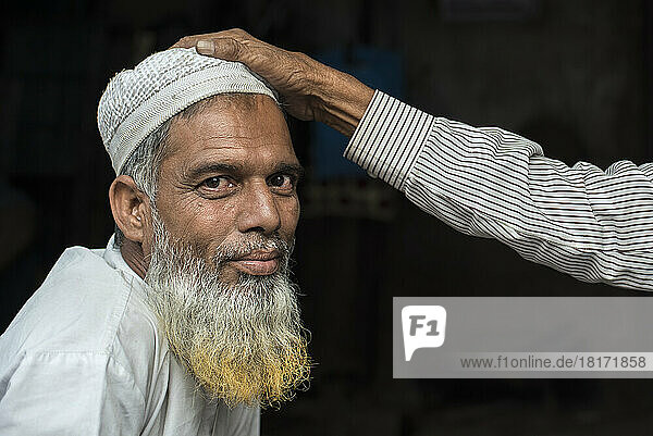 Hand auf dem Kopf eines muslimischen Ladenbesitzers in Jaipur  Indien; Jaipur  Rajasthan  Indien