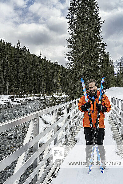 Woman stands with her skis on a trail while cross-country skiing in Banff National Park  Alberta  Canada; Improvement District No. 9  Alberta  Canada