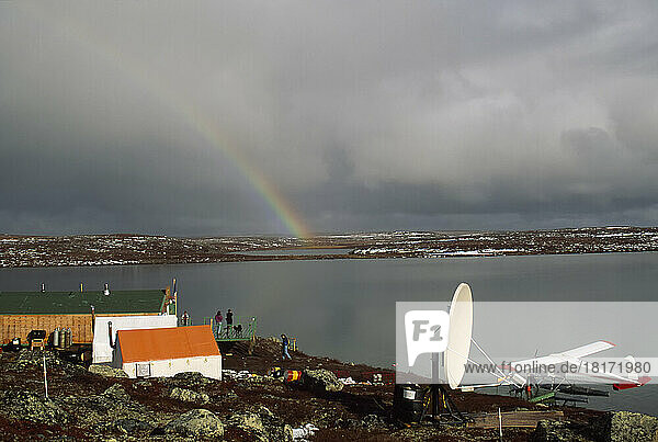 Diamantminencamp mit Wasserflugzeug  Satellitenschüssel und Gebäuden sowie einem Regenbogen in den Gewitterwolken in der Ferne; Yellowknife  Nordwest-Territorien  Kanada