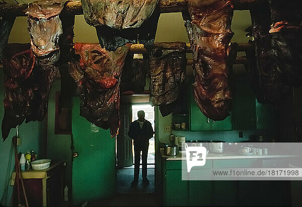 Ein Dene-Mann betritt einen Raum  in dem Karibufleisch von der Decke hängt  in der Nähe von Yellowknife  NWT  Kanada; Nordwest-Territorien  Kanada