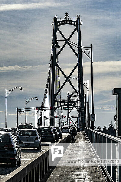 Lions Gate Bridge with road traffic and a cyclist; Vancouver  British Columbia  Canada