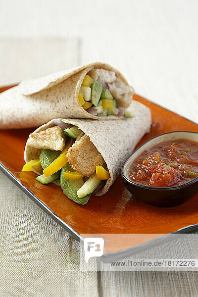 Fish with peppers and cucumber in a whole grain wrap