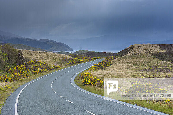 Winding country road with an overcast sky in springtime on the Isle of Skye in Scotland  United Kingdom