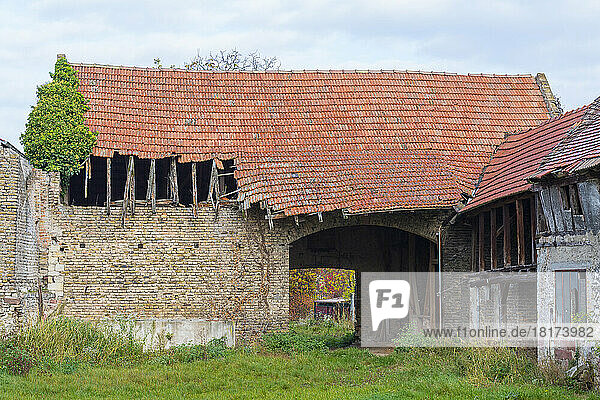 Old stone barn with broken corrugated roof in Hesse  Germany