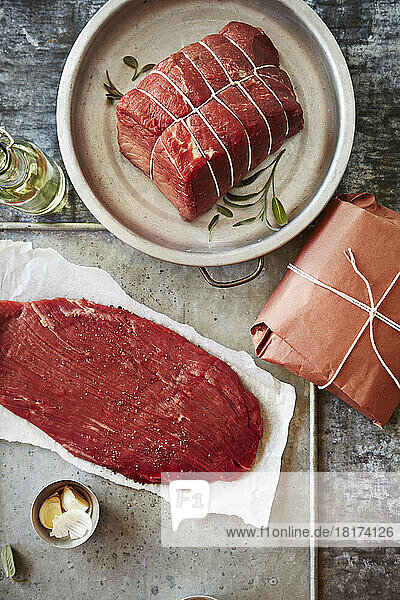 Still life of beef with butcher paper on a metal background