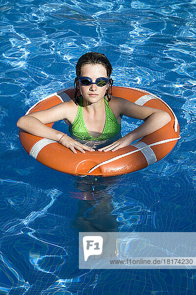 Girl in Swimming Pool With Life Preserver