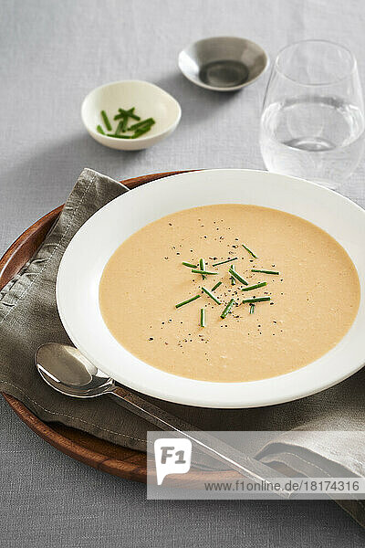 Bowl of seafood bisque soup with chives and pepper