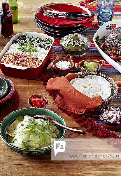 Mexican holiday feast with roast pork and dishes of rice  salad and tortillas