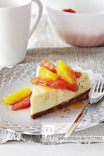 Slice of ricotta cheesecake with citrus and syrup on top