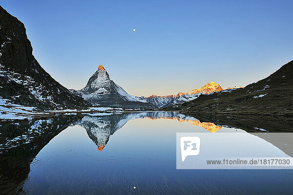 Matterhorn reflected in Lake Riffelsee at Sunrise with Moon  Zermatt  Alps  Valais  Switzerland