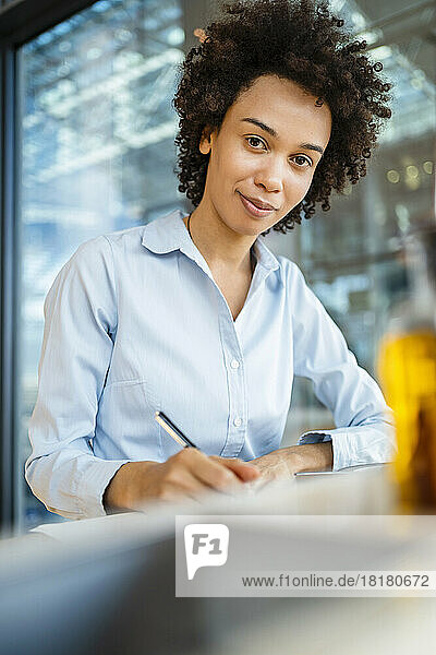 Smiling businesswoman with curly hair at office