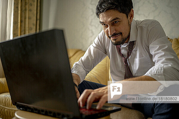 Determined businessman working on laptop at home