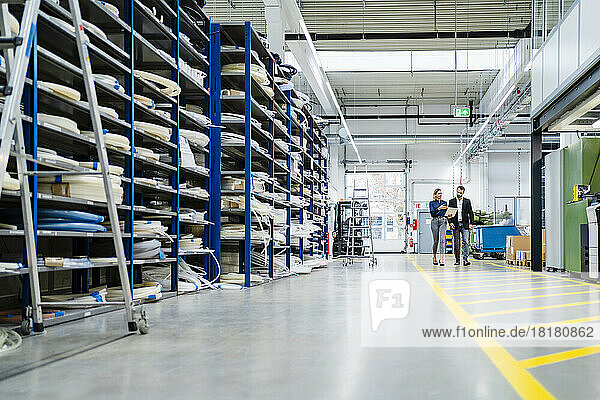 Business colleagues walking in warehouse at factory