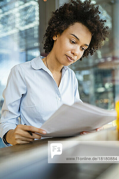 Businesswoman reading documents at office
