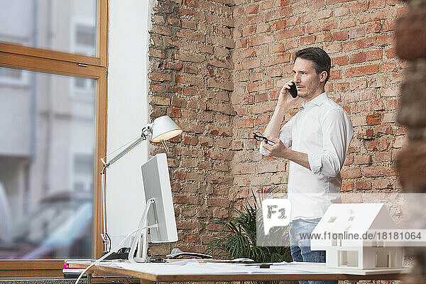 Businessman talking on mobile phone at work place