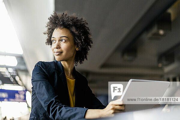 Contemplative businesswoman with tablet PC