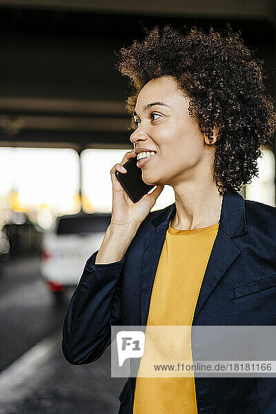Lächelnde Geschäftsfrau  die am Smartphone spricht