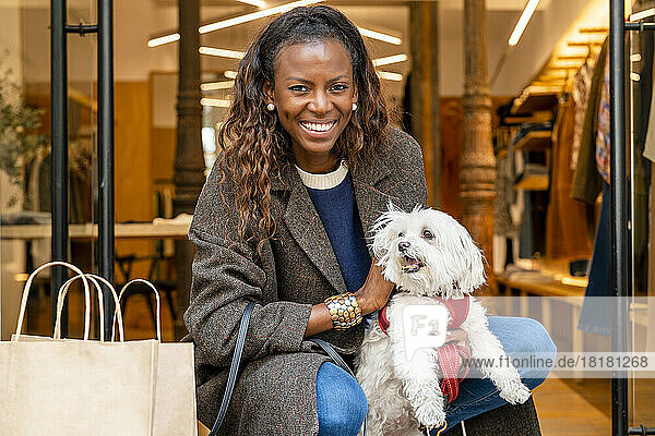 Happy woman with dog in front of boutique