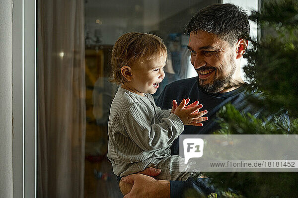 Happy father with son looking at Christmas decoration at home