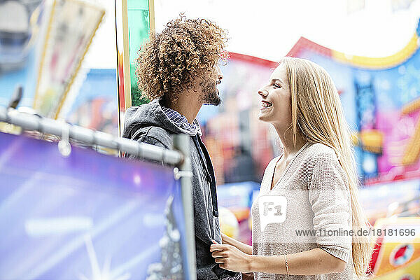 Glückliches Paar auf einem Karussell auf einem Jahrmarkt