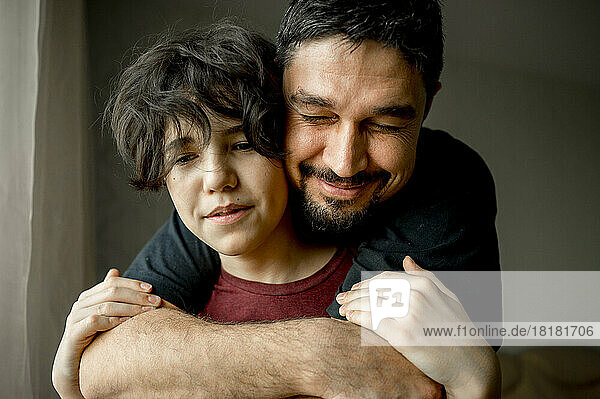 Lächelnder Vater umarmt Sohn zu Hause