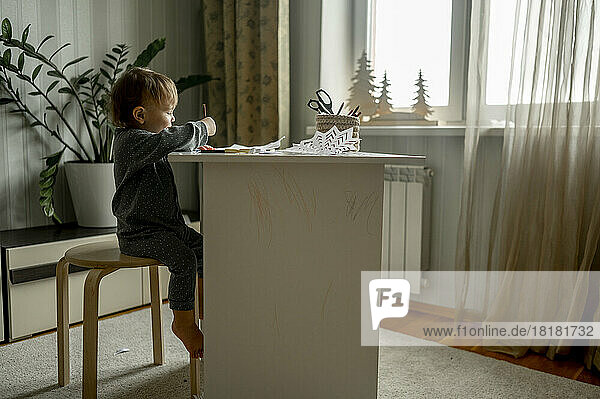 Kleinkind zeichnet am Tisch