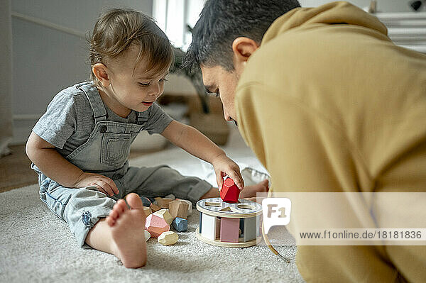 Vater und Sohn spielen zu Hause mit Holzspielzeug
