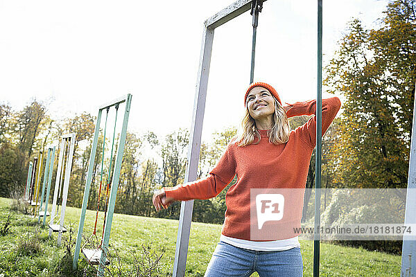 Lächelnde reife Frau träumt von der Schaukel im Park