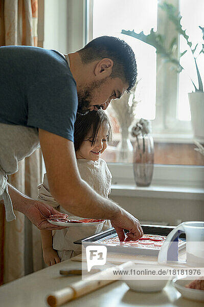 Father and son preparing pizza together at home