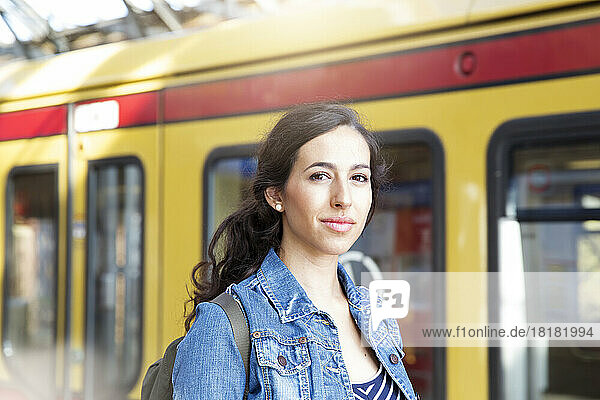 Germany  Berlin  portrait of young woman in front of city train